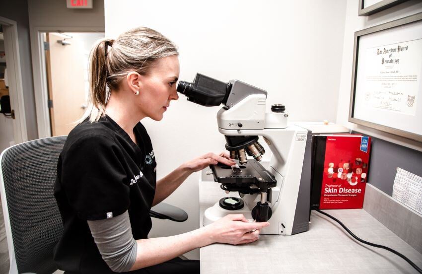 Dr. Ortleb looking through a microscope